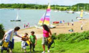 Sailing boats and family on beach walk